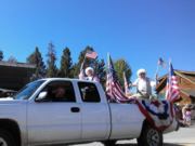 A thumb nail view of Grand Lake, Colorado during Constitution Week in September looking at a white pick-up with flags, patriots, and flag bunting looking very patriotic; click here to open a window with a larger picture.